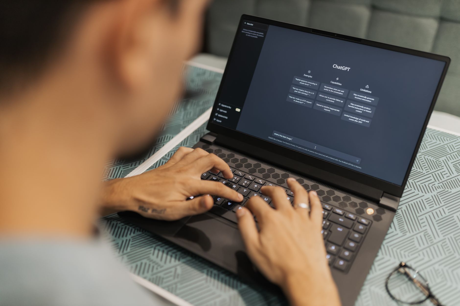 Person typing on a laptop with an AI chat interface on screen